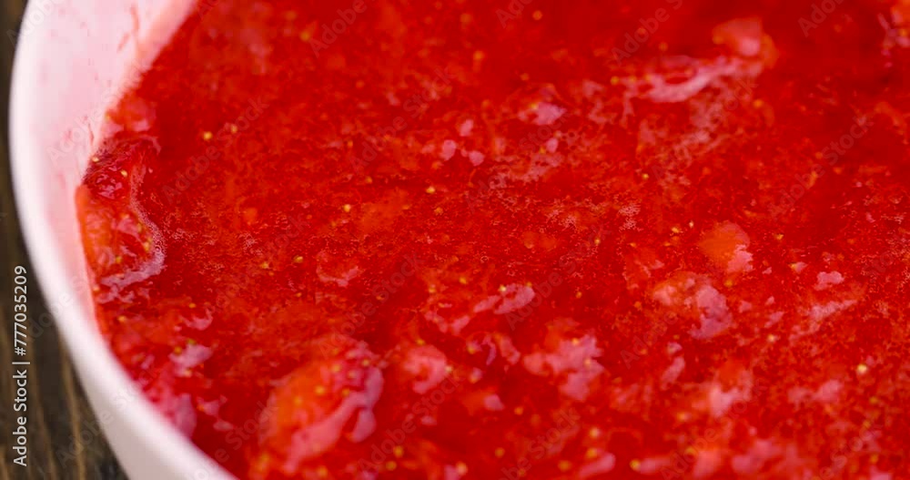 grated red ripe strawberries during cooking, juice and pieces of strawberries after pressing