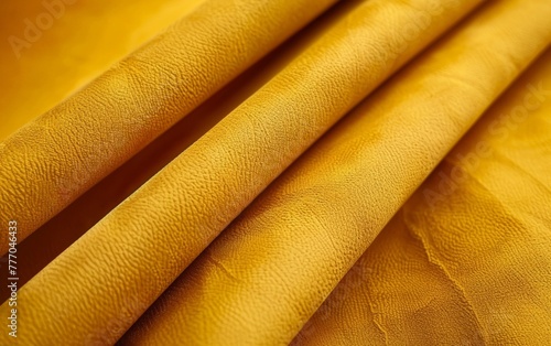 A close-up shot of a vibrant mustard-colored fabric with a rich, textured surface, creating a visually captivating and tactile pattern. Velvety alcantara texture