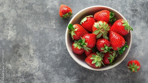 Ripe strawberries in a bowl on a gray background, juicy berries, vitamins.