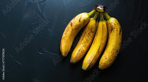 A bunch of bananas on a black background. An exotic fruit. Delicious and juicy bright yellow bananas.