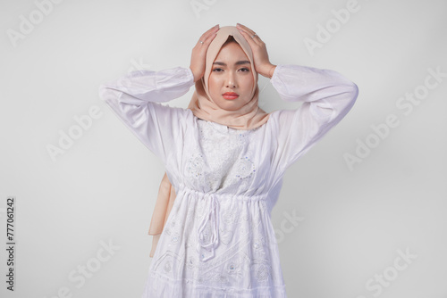 Sad Asian Muslim woman in hijab looks stressed and depressed or having headache because hot weather and fasting