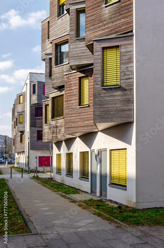 Berlin, Germany, March 7, 2024: street with housing block with white plaster facade and wooden bay windows in Adlershof neighbourhood