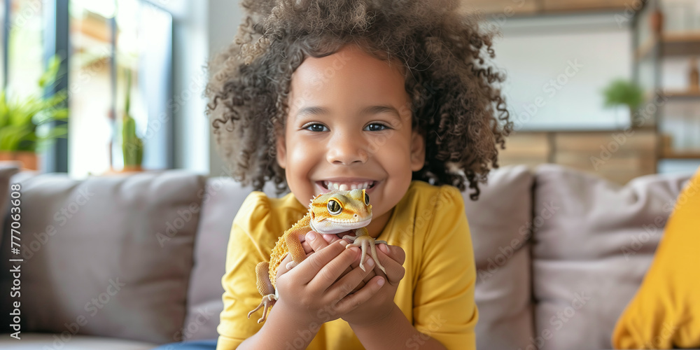 Cute young child holding her pet gecko in sunny living room. Kid and her best reptile friend at home. Cute young child holding her pet gecko in sunny living room. Kid and her best reptile friend at home.
