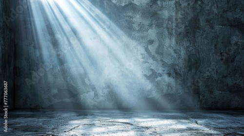 Dramatic light rays penetrating through an opening into a dark concrete room.