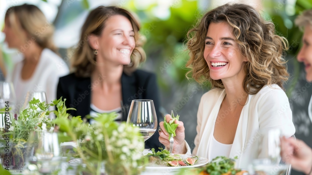 Senior friends dining happily with focus on woman in nursing home, blurred background for text