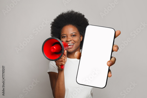 Attractive woman with loudspeaker and empty blank screen display phone. Female with smartphone