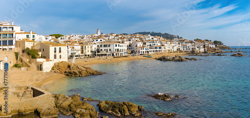 Panorámica de Calella de Palafrugell, donde las casas blancas con detalles azules se mezclan con el paisaje costero rocoso y las aguas del Mediterráneo.