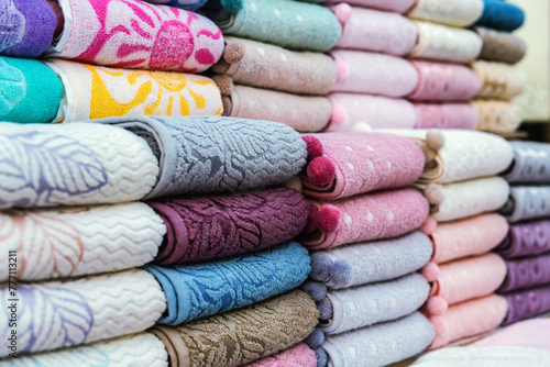 Rows of neatly stacked Turkish towels, rich in color and pattern, display premium textile craftsmanship
