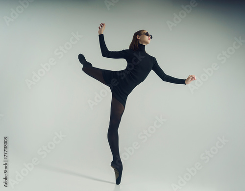 Fototapeta Naklejka Na Ścianę i Meble -  young ballerina in a black dress and sunglasses total black makes an attitude
