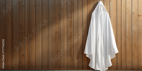 a white mock up smple of a white hodded bathrobe hanging infront of a pollished wood wall сreated with Generative Ai photo