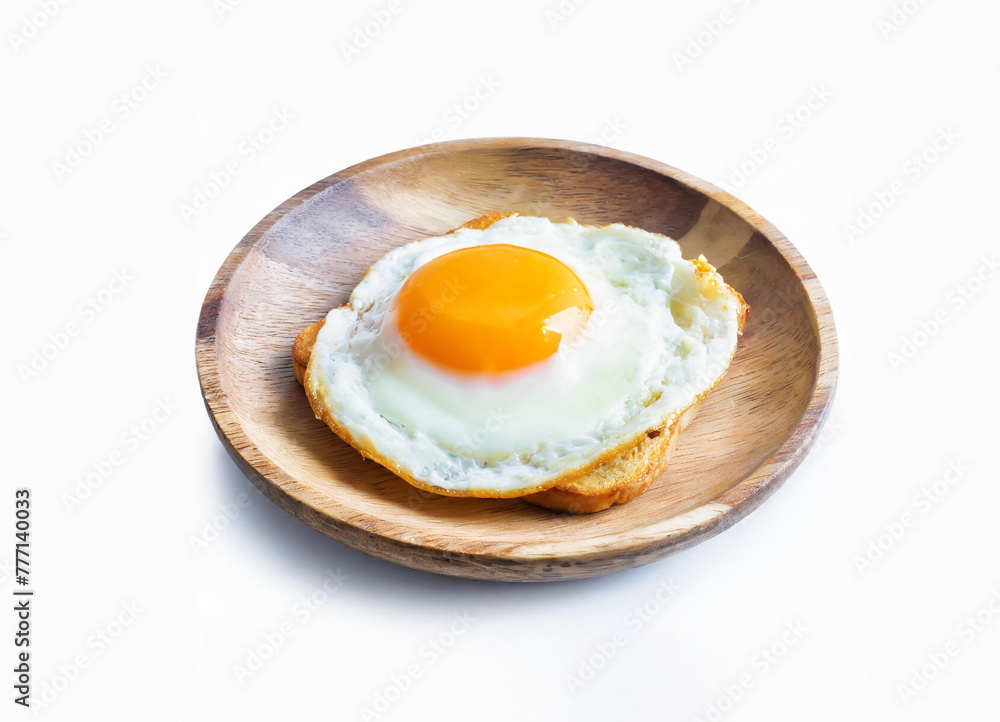 A round fried egg with a bright orange yolk sits on a plate A round fried egg with a bright orange yolk sits on a plate
