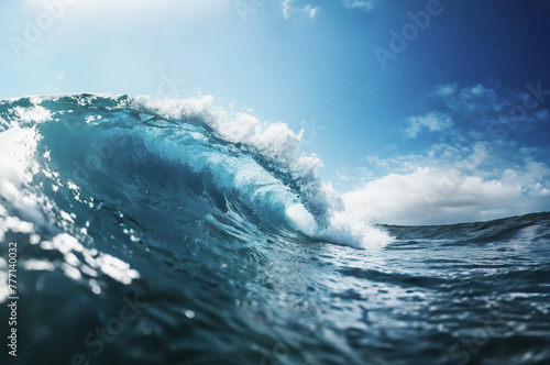 Powerful blue ocean wave crashes on the shore, sending white foam splashing into the summer sky
