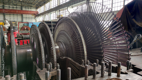 Disassembled steam turbine in the process of repairing and electric generator at power plant