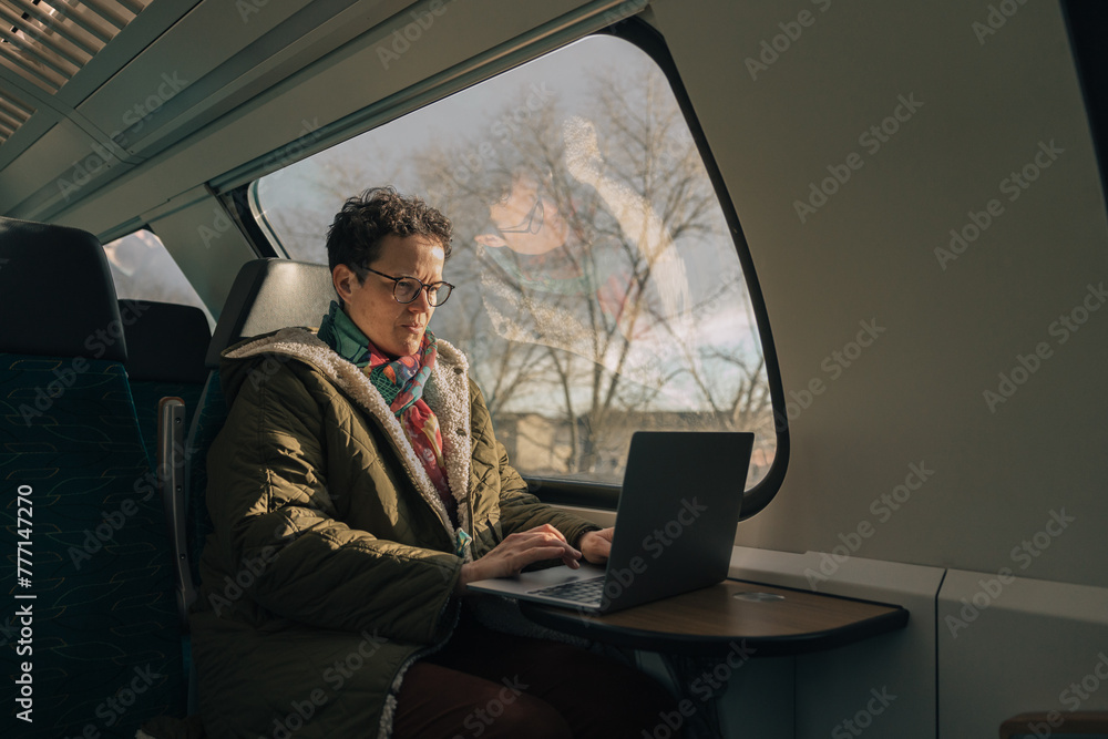 Woman working on laptop while traveling by train