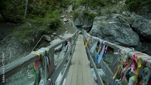 Authentic bridge adorned with Buddhist prayer flags. The scene captures cultural and spiritual elements, with colorful flags fluttering in the wind, creating a serene and picturesque atmosphere.