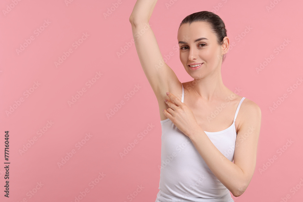 Beautiful woman showing armpit with smooth clean skin on pink background, space for text Beautiful woman showing armpit with smooth clean skin on pink background, space for text