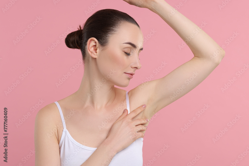 Beautiful woman showing armpit with smooth clean skin on pink background Beautiful woman showing armpit with smooth clean skin on pink background