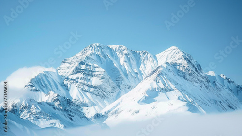 Magnificent mountain range covered in a blanket of snow  against a clear blue sky.
