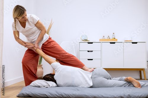 Female masseuse doing a relaxing Thai massage photo