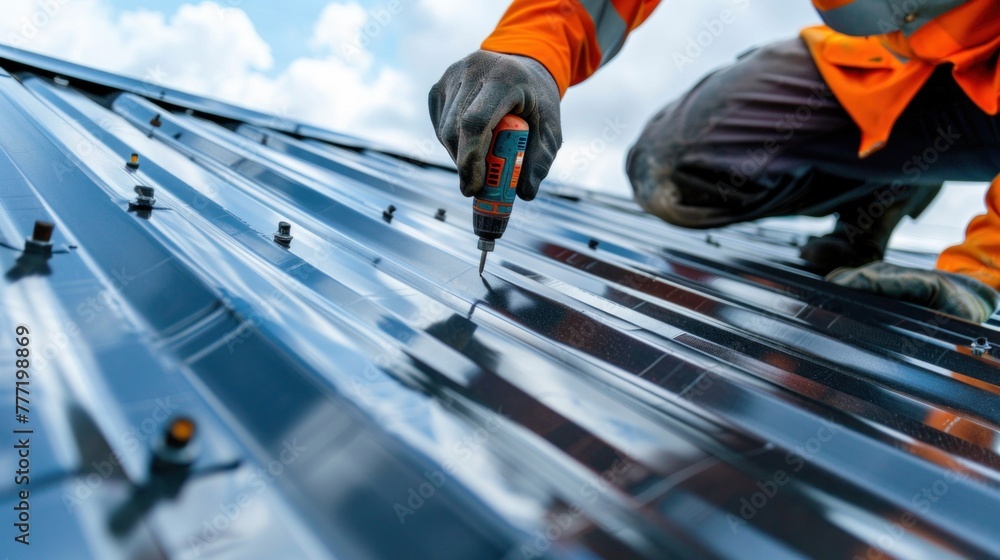 Black metal sheet roof installed by a professional roofer. The roofer uses a drill to shoot screws into the roof. Black metal sheet roof installed by a professional roofer. The roofer uses a drill to shoot screws into the roof.
