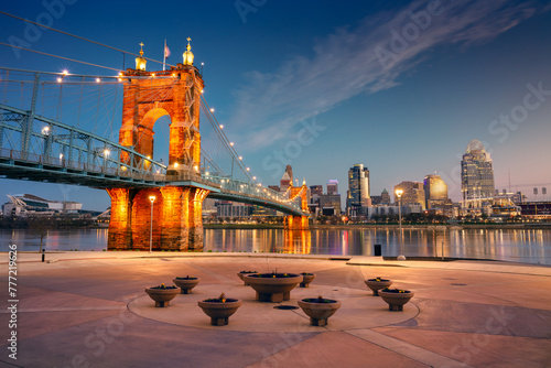 Cincinnati, Ohio, USA. Cityscape image of Cincinnati, Ohio, USA downtown skyline with the John A. Roebling Suspension Bridge and reflection of the city in the Ohio River at spring sunrise.