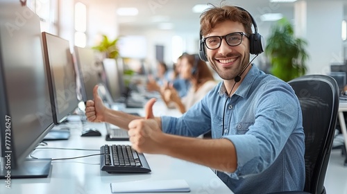 Positive male customer service agent giving thumbs up in modern call center with bright lighting