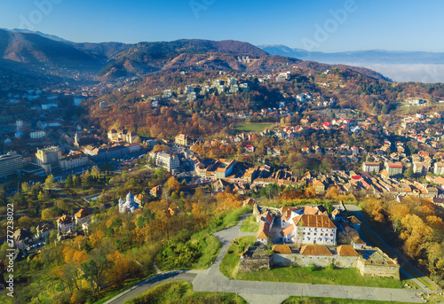 Aerial drone view of the city of Brasov in Romania with historic houses at the foot of the Tampa hill in Transylvania, in the autumn season.