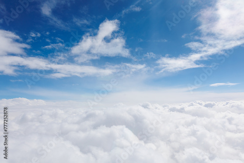 Fototapeta Naklejka Na Ścianę i Meble -  Cumulus clouds float in a bright blue sky stretching to the horizon