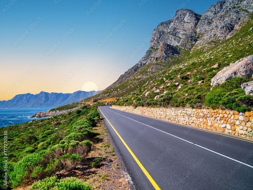 Winding road R44 along indian ocan with lush bush and rugged mountain at Kogel Bay, Cape Town, South Africa