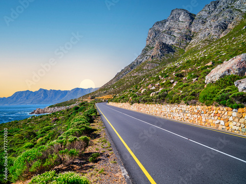 Obraz na płótnie Winding road R44 along indian ocan with lush bush and rugged mountain at Kogel Bay, Cape Town, South Africa w salonie