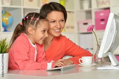 Close up porait of mother and daughter using laptop photo