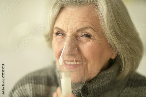 Obraz na płótnie Elderly woman is sick and uses an inhaler w salonie