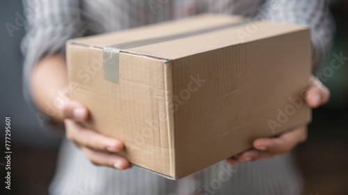 Close-up of a worker carrying cardboard box while making a delivery. 