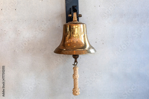 Bilde på lerret Brass bell on a gray wall indoors.