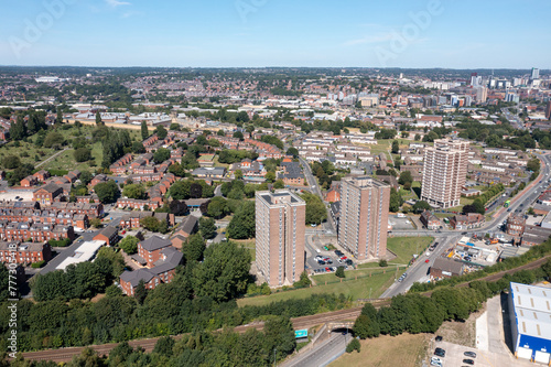 Aerial drone photo of the village of Wortley in Leeds, West Yorkshire in the UK showing houses estates and blocks of flats in the city by the train tracks.