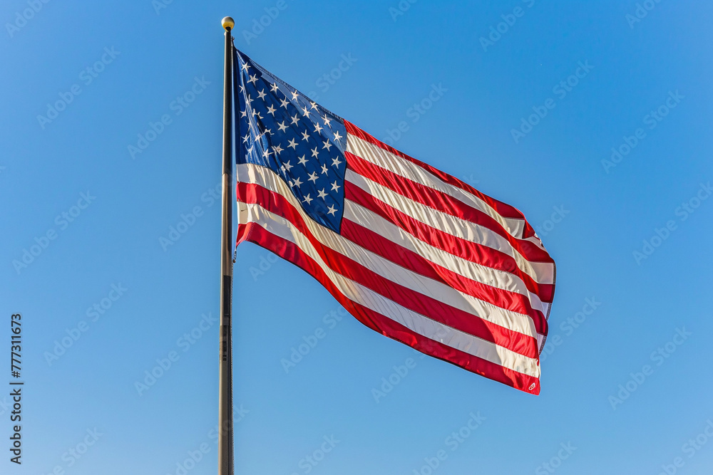Fototapeta premium American Flag Waving Against Blue Sky