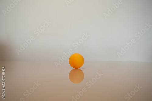 a yellow ping pong ball on a table © gustavo