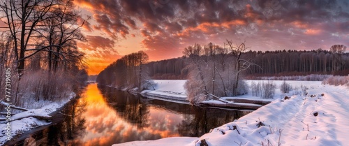 Serene peaceful rural winter sunset landscape over the river with clouds reflection and road covered with snow