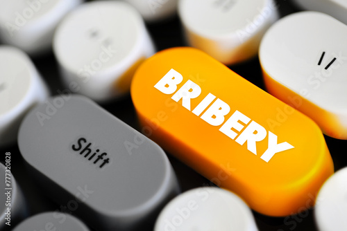 Bribery is the offering, giving, receiving, or soliciting of any item of value to influence the actions of an official, text concept button on keyboard