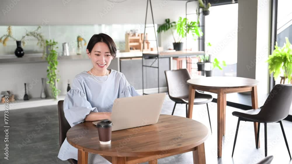 綺麗なオフィスやカフェでパソコンで仕事をする笑顔の美人なアジア系(日本人)女性の動画 綺麗なオフィスやカフェでパソコンで仕事をする笑顔の美人なアジア系(日本人)女性の動画
