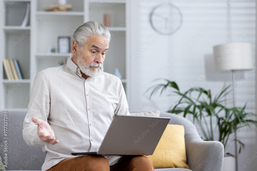 Senior man with a surprised expression using a laptop at home Senior man with a surprised expression using a laptop at home