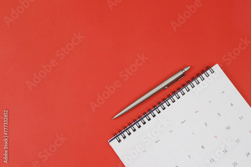 A pen with calendar on red background. © methaphum
