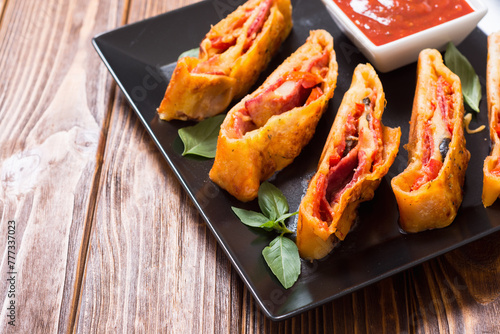 Pizza roll stromboli with cheese salami olives and tomatoes