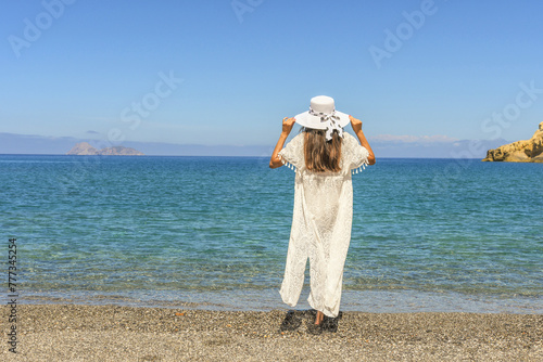 Happy woman in a hat on a tropical beach. Summer vacation concept.