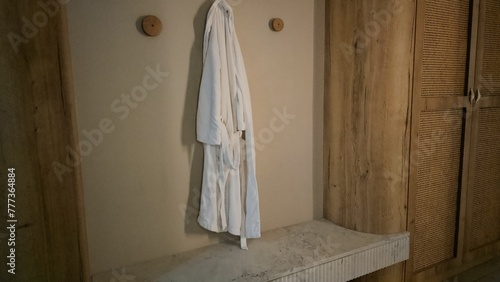 White Robe Hanging Next to a Door