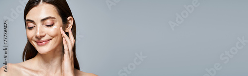 Wallpaper Mural Caucasian woman with brunette hair gently touches her face and applying cream, tranquility and self-care, banner Torontodigital.ca