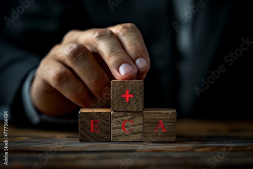 Using deft finger and thumb movements, the person skillfully stacks hardwood blocks in a game of indoor recreation. The wrist flicks with precision in the darkness photo