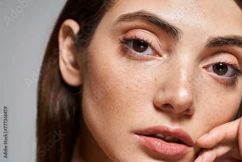 Canvas-taulu A close-up of a young Caucasian woman with mesmerizing brown eyes and clean skin in a studio setting