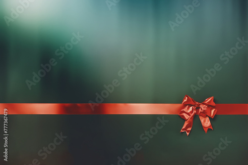 nœud et ruban rouge en bolduc d'un paquet cadeau sur un emballage vert en papier métallique pour période de Noël. Espace négatif copy space