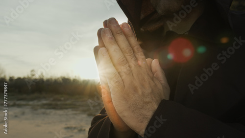Hands Of A Monk Praying At Sunset In Countryside Nature